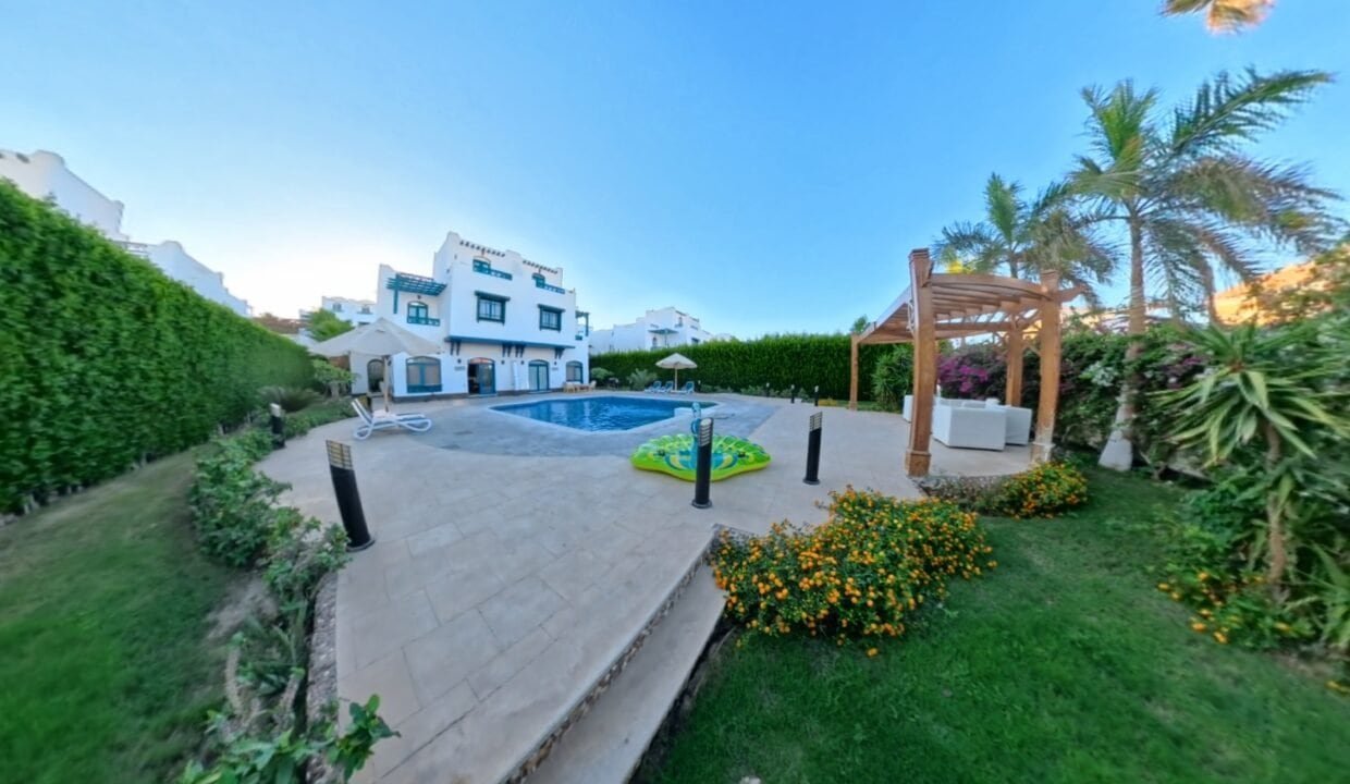 Outdoor view of a luxurious villa with a swimming pool and lush garden in Hurghada, Egypt.