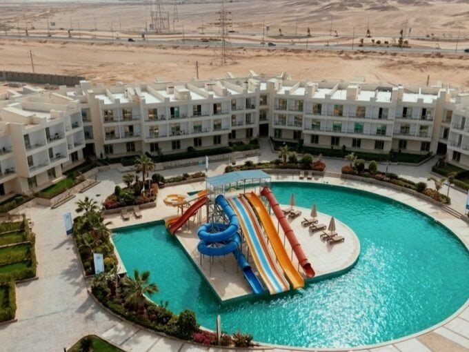 Resort pool with water slides and sun loungers in Hurghada, Egypt.