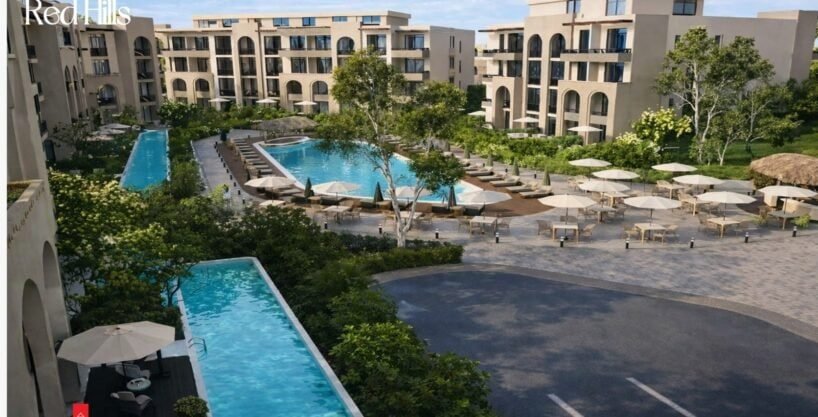 Modern pool with sun loungers and greenery at Trivana, Hurghada.