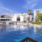 AL Mouj Resort Magawish - crystal lagoon entertainment area with turquoise water and lounge seating